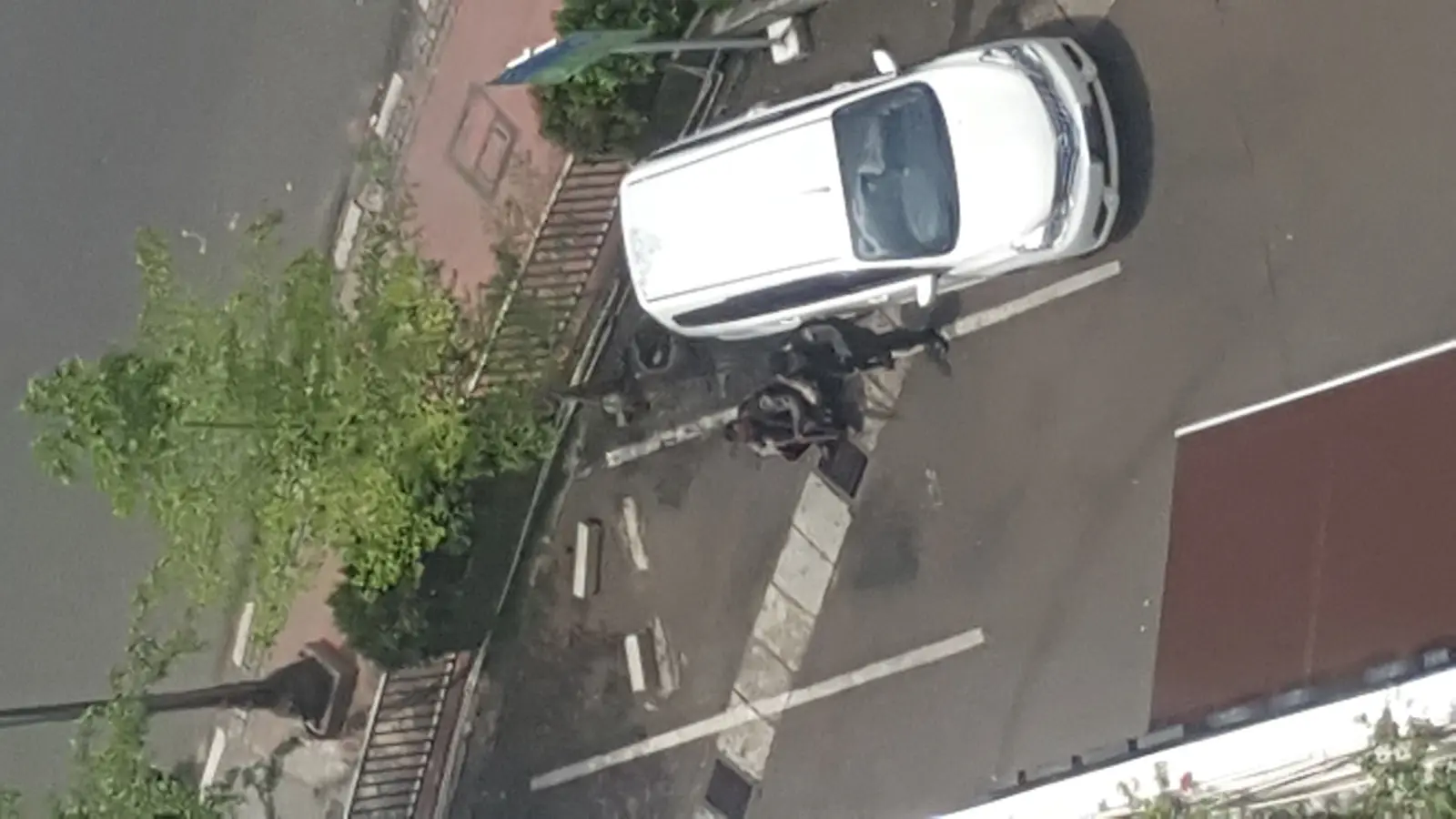 Two police officers taking cover behind a parked car in the service road